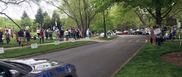 Andrew Cooperrider, a Lexington coffee-shop owner who has led protests against Gov. Andy Beshear's emergency orders, spoke to a group of his allies in front of a "Don't Tread on Me" flag at the Capitol Sunday. Across the way was a group supporting Beshear.