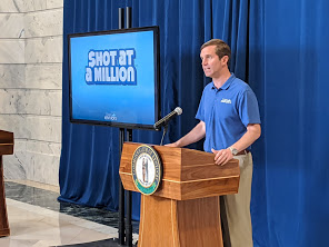 Andy Beshear standing at a lectern